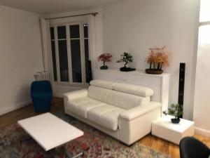 uma sala de estar com um sofá branco e uma mesa em Read Well - Spare Double Bedroom in Cosy Appartment close to Convention Center in 15th District em Paris