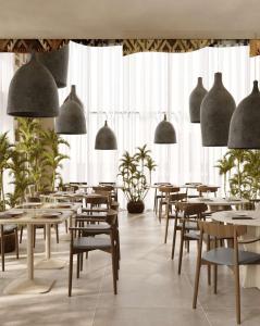 a restaurant with tables and chairs and large windows at Savotel in Golem