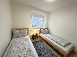 two beds sitting in a room with a window at Ferienwohnung Niederthalheim 