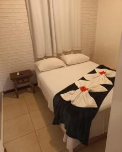 ein Schlafzimmer mit einem Bett, auf dem zwei Handtücher liegen in der Unterkunft Apartamento Studio - Solar Pipa in Pipa