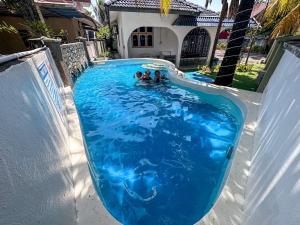 un grupo de personas nadando en una piscina en SM VILLA LANGKAWI full privacy home with pool, en Kuah