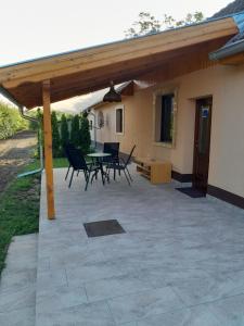 patio con tavolo e sedie sotto un pergolato in legno di Apartman Pored Jezera a Palić