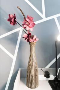 バーミンガムにあるExclusive Studio Retreatの机の上に座ったピンクの花瓶