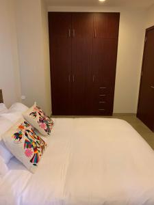 ein Schlafzimmer mit einem großen weißen Bett mit zwei Kissen in der Unterkunft Apartamento en el Barrio de POLANCO . GREAT APARTMENT/ MEXICO CITY in Mexiko-Stadt