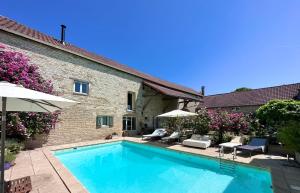a swimming pool in front of a house at La Cour des Délices in Gigny