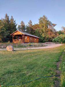 una cabaña de madera en un campo junto a un campo en Treimani Hoovimaja, en Treimani
