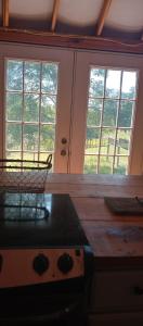 een keuken met 2 ramen, een tafel en een fornuis bij Madison's ONLY yurt experience! in Vevay