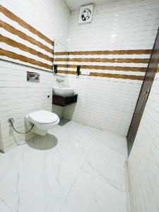 a bathroom with a white toilet and a sink at Hotel The Golden Taj By The Golden Taj group & Hotels in Agra