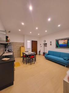 ein Wohnzimmer mit einem blauen Sofa und einem Tisch in der Unterkunft Marta's Home in Molfetta