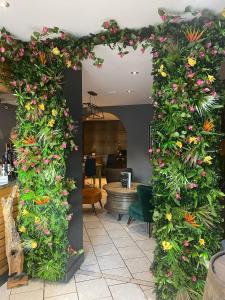une arche recouverte de fleurs et de plantes dans une pièce dans l'établissement Imaginarium restaurant, à Barton-upon-Humber