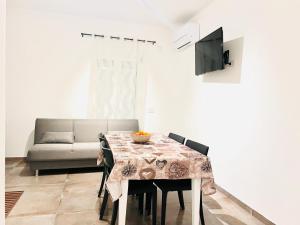 ein Esszimmer mit einem Tisch und einem Sofa in der Unterkunft S'Aneddu e Oro in Alghero