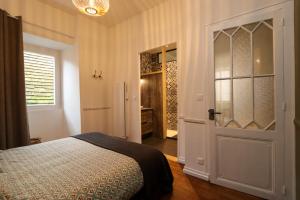 a bedroom with a bed and an open door at Appartement La Couronne Sarlat-La-Canéda in Sarlat-la-Canéda