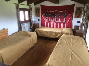 - 2 lits dans une chambre avec un panneau de baseball sur le mur dans l'établissement Casa del Sole Borgo Prediera, 