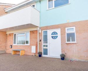 a house with a white door and a bench outside at The Portwey Pearl in Rodwell