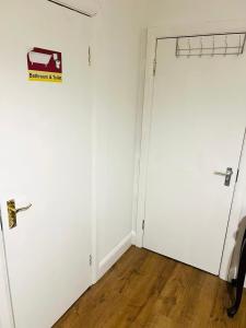 a white room with two doors and a wood floor at Double bed Room in London