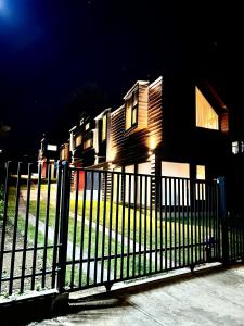 una cerca frente a una casa por la noche en AncudLodge en Ancud