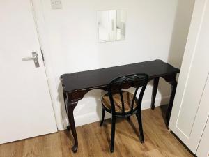 a black desk with a chair next to a door at Double bed Room for Couple tidy room Room 4 in London