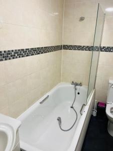 a bathroom with a bath tub and a toilet at Double bed Room for Couple tidy room Room 4 in London