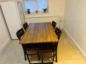 a wooden table with chairs in a room at Double bed Room for Couple tidy room Room 4 in London