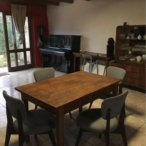 cocina con mesa de madera, sillas y piano en Casa con PISCINA - Consulte descuentos! en General Racedo