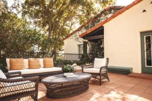 um pátio com cadeiras de vime e um sofá em El Encanto, A Belmond Hotel, Santa Barbara em Santa Bárbara