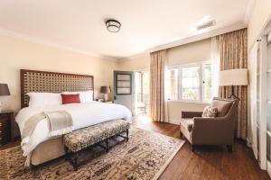 um quarto com uma cama grande e uma cadeira em El Encanto, A Belmond Hotel, Santa Barbara em Santa Bárbara