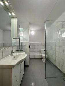 a white bathroom with a sink and a toilet at Apartament Stadion - duży apartament blisko Stadionu Narodowego w Warszawie. in Warsaw
