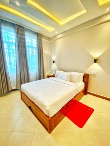 a bedroom with a large white bed with a red rug at Nexa Hotel in Arusha