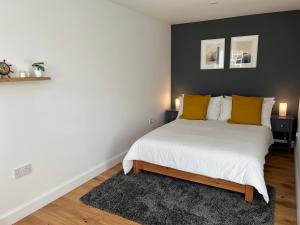 a bedroom with a large white bed with yellow pillows at Tiny House in Cosy Village in Milnathort