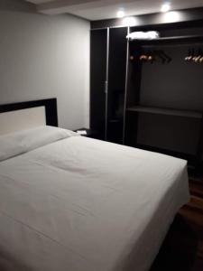 a bedroom with a white bed and a closet at Loft em Caldas da Imperatriz - SC in Santo Amaro da Imperatriz