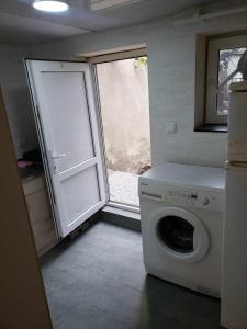 a laundry room with a washing machine and a window at My hom 2 in Kiketʼi
