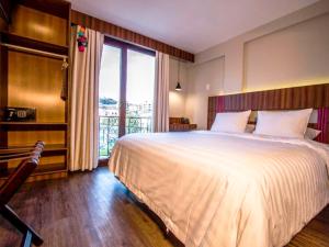 a bedroom with a large bed and a large window at Altus Express Hotel in La Paz