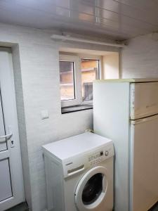a small kitchen with a washing machine and a refrigerator at My hom 2 in Kiketʼi