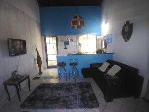 a living room with a black couch and stools at Beleza de Angra Apartamento Aconchegante in Angra dos Reis