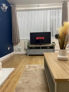 ein Wohnzimmer mit einem Flachbild-TV auf einem Tisch in der Unterkunft Spacious 4-bed House in Leicester in Leicester
