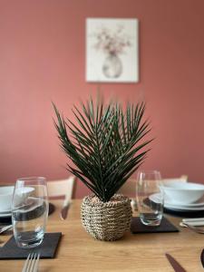 a table with two glasses and a potted plant on it at Spacious 4-bed House in Leicester in Leicester