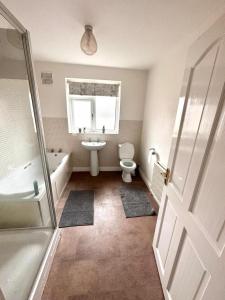y baño con aseo, bañera y lavamanos. en Spacious 4-bed House in Leicester, en Leicester