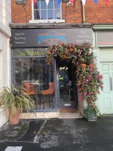 una entrada a un restaurante con flores en la entrada en Imaginarium restaurant en Barton upon Humber
