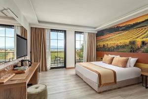 una habitación de hotel con una cama y una pintura de un viñedo en Wiyana Wanda en Elmalı