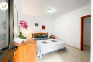 a bedroom with a bed and a dresser with at Las Playitas Sport&Golf in Las Playas