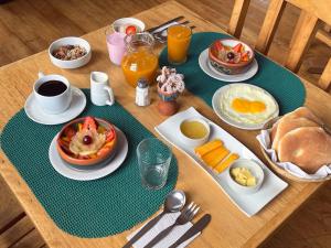 a wooden table with breakfast food on it at SAUCE Hotel Boutique in Ollantaytambo