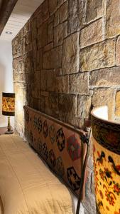 a stone wall with a bed in front of a brick wall at Villa Luxury nel Bosco in Castelbuono