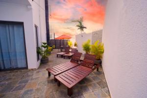 une terrasse avec des bancs et une peinture représentant un coucher de soleil dans l'établissement Golden Square Villa & Private Pool, à Flic-en-Flac