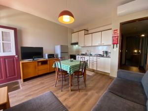 a kitchen with a table and chairs in a room at Apartamentos São João in Horta