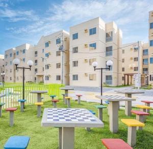 um grupo de mesas de piquenique em frente a um edifício em Apartamento, 2 quartos com piscina em Paulista