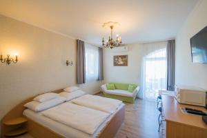 - une chambre à l'hôpital avec un lit et un canapé dans l'établissement Jade Panzio, à Balatonföldvár