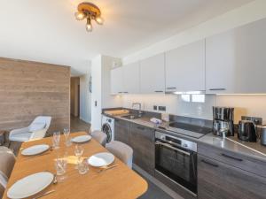 a kitchen with a wooden table with white plates on it at Bel appartement près des pistes, WiFi, animaux admis, parking - FR-1-645-46 in LʼHuez +6 photos