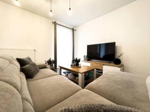 a living room with a couch and a flat screen tv at Apartament 101 Kępa Mieszczańska in Wrocław