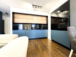 a kitchen with blue cabinets and a counter top at Apartament 101 Kępa Mieszczańska in Wrocław