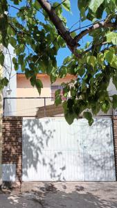 un edificio con una puerta de garaje blanca y un árbol en Departamento céntrico en San Rafael